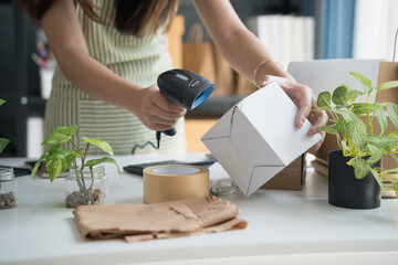 Asian Women Entrepreneurs in SME Using Laptops to Process Online Orders and Manage Parcel...
