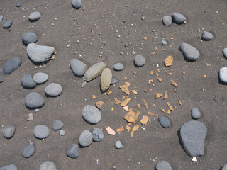 Fragments of ancient pottery weathered from the sand on Ainu settlement archeological site on Iturup, Kuril Islands