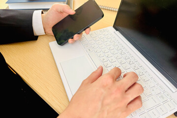 	スマホとパソコンで作業するビジネスマン