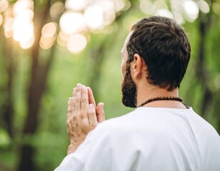 Man in prayerful pose in forest