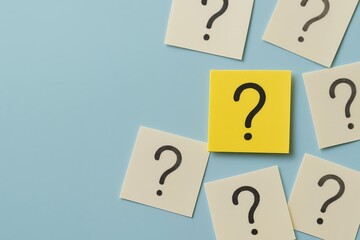 Close up of question mark notes on light blue background with one standout yellow note, concept for problem solving, brainstorming and decision making inquiries