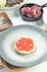 Serabi pancakes topped with strawberry jam, a traditional Indonesian snack