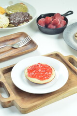 Serabi pancakes topped with strawberry jam, a traditional Indonesian snack