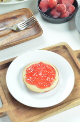 Serabi pancakes topped with strawberry jam, a traditional Indonesian snack