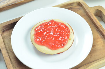 Serabi pancakes topped with strawberry jam, a traditional Indonesian snack