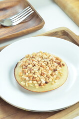 Serabi pancake with peanut topping and condensed milk, a traditional Indonesian snack