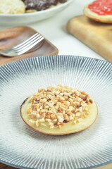 Serabi pancake with peanut topping and condensed milk, a traditional Indonesian snack