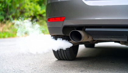 Exhaust Emission:  A car's exhaust pipe releases emissions, captured in a detailed shot, which underscores the impact of automobiles on air quality and the environment. 