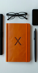 High-quality image of an elegant orange leather notebook with the letter 'X' embossed on the cover, showcasing the structure and craftsmanship.