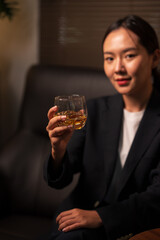 Businesswoman holding a glass of whiskey