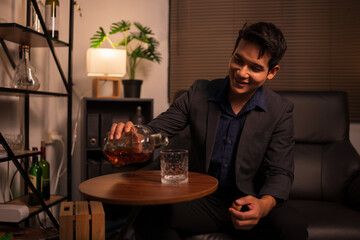 Businessman holding a glass of whiskey in a restaurant sitting on a sofa
