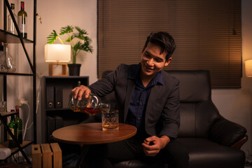 Businessman holding a glass of whiskey in a restaurant sitting on a sofa