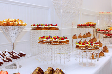 Stunning variety of pastries desserts is elegantly arranged on crystal displays at an upscale event.