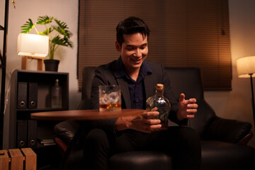Businessman holding a glass of whiskey in a restaurant sitting on a sofa