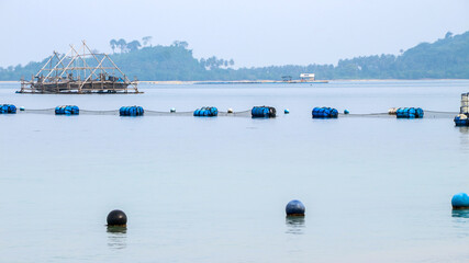 a float or pontoon, made from a used barrel or drum, used to float a net or structure in water, such as in fish farming in floating cages. © R_yuliana
