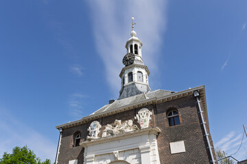 Fototapeta premium The historic Zijlpoort gate in Leiden with a clock tower and intricate architectural details under a clear blue sky, showcasing European heritage.