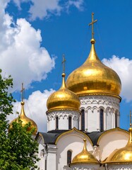 Golden domes of a cathedral against a cloudy sky