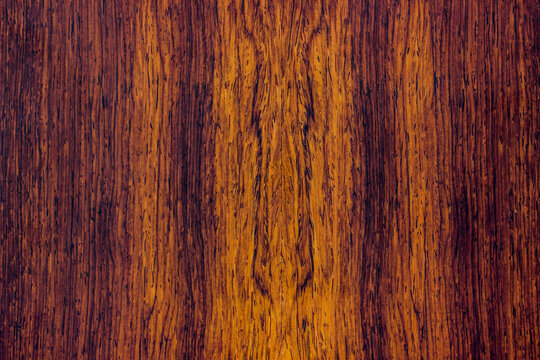 natural wood, with a beautiful pattern. natural wood background. wooden board with natural seamless texture. Cocobolo, Dalbergia, red wood, view from above, horizontal
