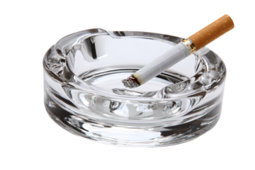 Burning cigarette in a glass ashtray