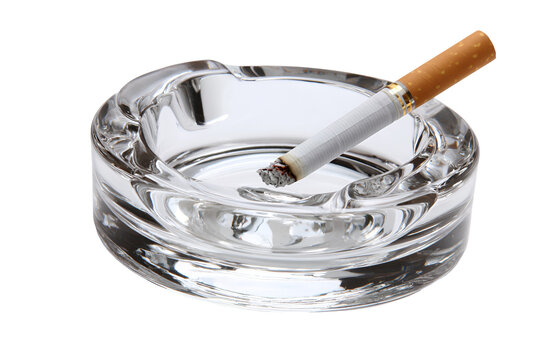 Burning cigarette in a glass ashtray