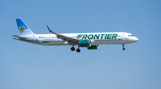 Frontier Airlines aircraft Airbus A321-271NX approaching Dallas Fort Worth International Airport (DFW), blue skies.