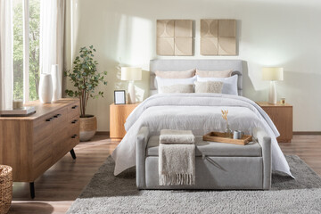 Japandi bedroom with grey upholstered bed, white quilted bedding, oak nightstands and dresser, ottoman bench tray, woven accents, neutral palette bathed in morning light creating a serene cozy retreat