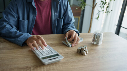 Man calculates finances by calculator Count banknotes and coinsใ