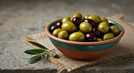 Delicious selection of green and black olives in minimalistic bowl on rustic background