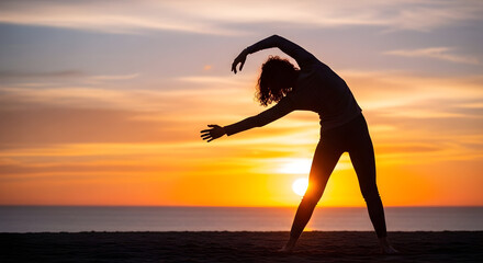 Silhouette of a person practicing yoga or stretching on the beach during sunset with vibrant orange and yellow sky creating a peaceful and inspiring atmosphere for relaxation and wellness