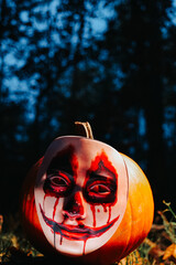 Bloody Pumpkin Monster. Scary pumpkin in the dark forest.Halloween wallpaper with a scary pumpkin