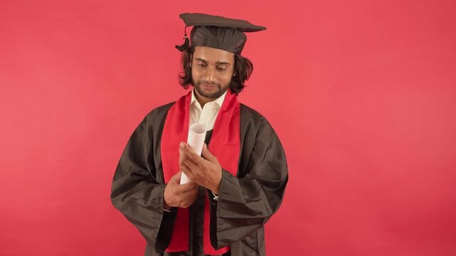 Scholar in convocation robe clutches degree with emotion