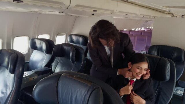 Both flight attendants laugh together in vacant cabin