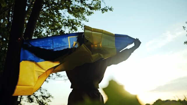 Low angle, woman holding Ukrainian flag in forest, strength global support shot