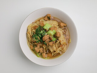 Chicken noodles and meatballs soup in white bowl 