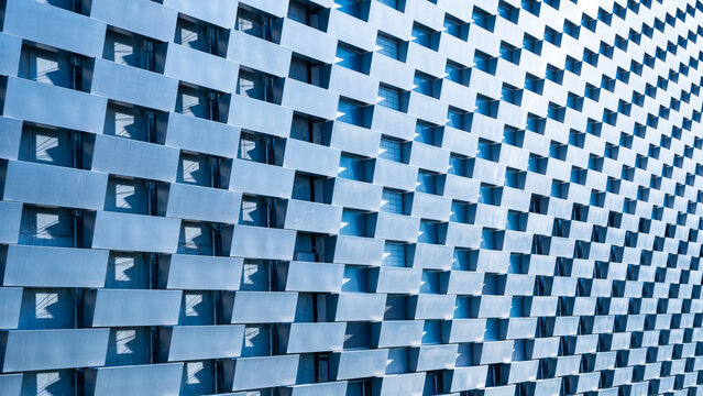 This architectural detail showcases the unique envelope facade of Amager Bakke in Copenhagen, Denmark. The innovative design features a striking pattern of reflective surfaces and cutouts.