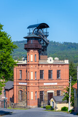 Sevcinsky mine in Brezove hory showcases its unique architecture under clear blue skies. The historic structure highlights the region's mining heritage and scenic landscape.