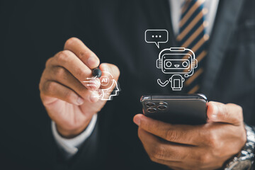 AI chatbot on a phone screen is used by a businessman to explore chat robot application, using a...