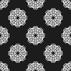 Elegant seamless pattern with white mandala floral lace motifs on a striking black background, perfect for bohemian, spiritual, or decorative designs.