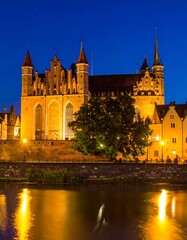 Obraz premium Medieval castle at night by river