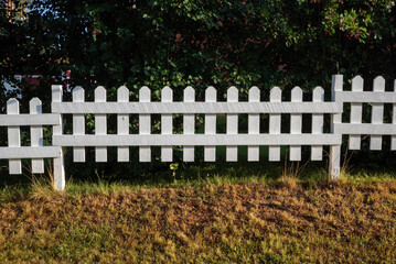 White picket fence and green bushes