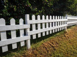 White picket fence and green bushes