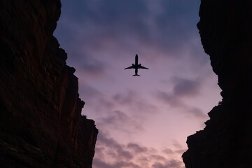 Fototapeta premium Airplane flying at sunset, Silhouette in rocky canyon, Travel journey through dramatic skies