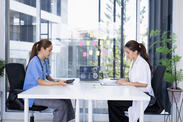 Female doctor and nurse working together, Two doctor woman working with x ray in modern clinic.