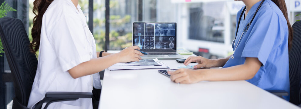 Female doctor and nurse working together, Two doctor woman working with x ray in modern clinic.