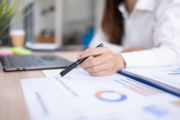 business woman pointing on analyzing financial charts at a desk.