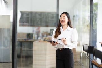 portrait of a businesswoman using a tablet computer standing in office.