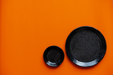 Black Ceramic Plates on Orange Background