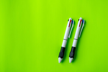 Two Multi-Color Pens on Bright Green Background