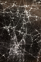 glass broken into many pieces on a dark background, close up