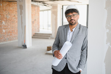 Arab Confident engineer holding blueprint at construction site